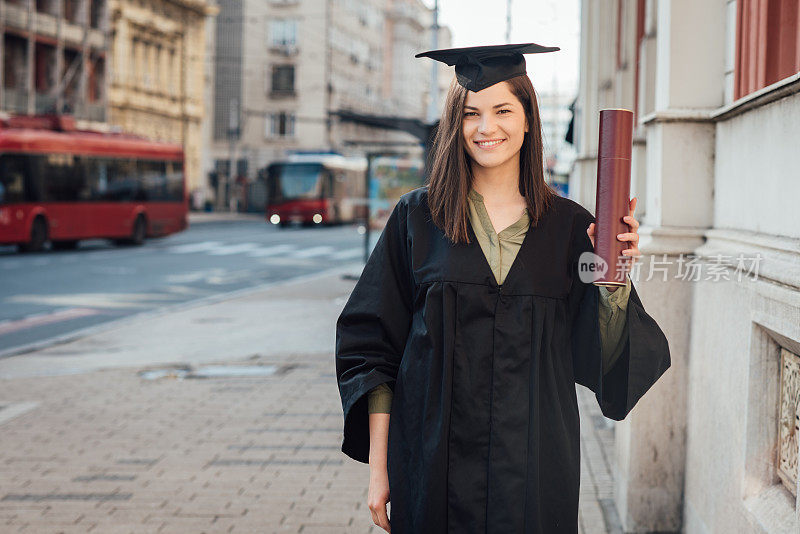 一位美丽的毕业生展示她的毕业证书的画像