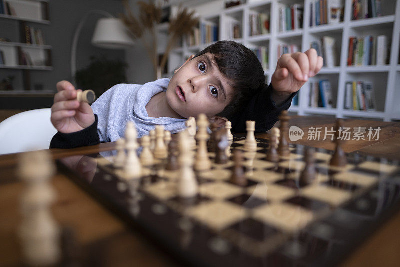 父亲和儿子一起在家里下棋。家人在家里。