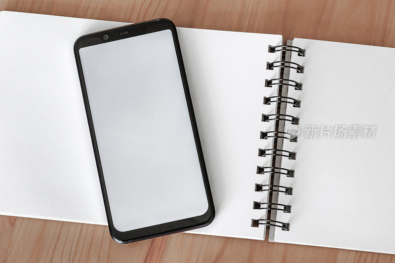 智能手机与白色屏幕上开放的笔记本覆盖模型