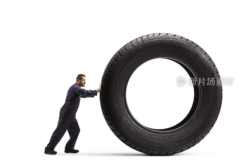 一个机械师推着一个大的汽车轮胎的全身剖面图