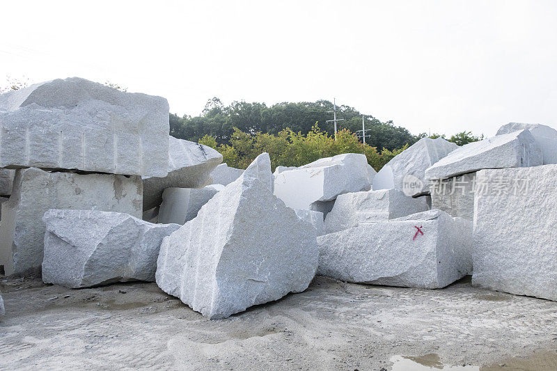 从天然采石场开采出来的成堆的重花岗岩。