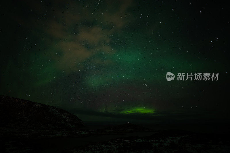 北极光在夜空中山脉的轮廓