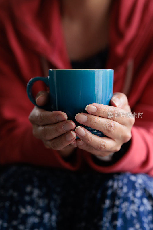 一个女人拿着咖啡杯