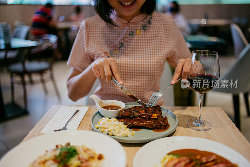 年轻女子在餐厅吃烧烤排骨