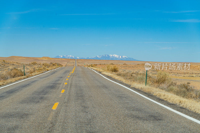犹他州东南部漫长而孤独的柏油路，远处是雪山