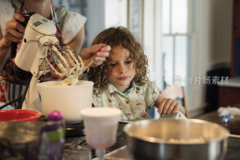 妈妈和小女儿在家里烤蛋糕。