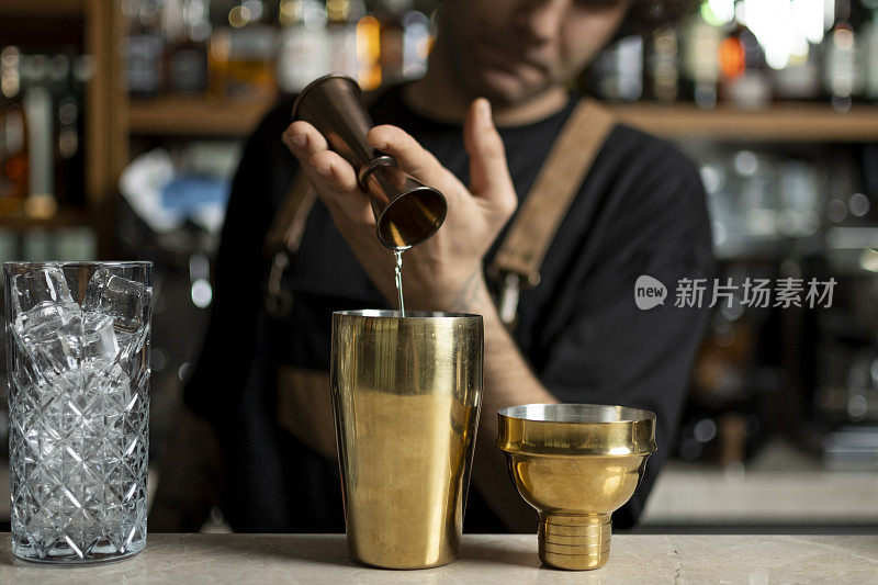 调酒师使用调酒器准备美味的鸡尾酒