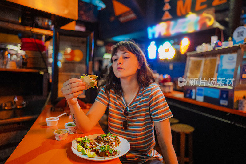 一个女人在酒吧里吃玉米卷