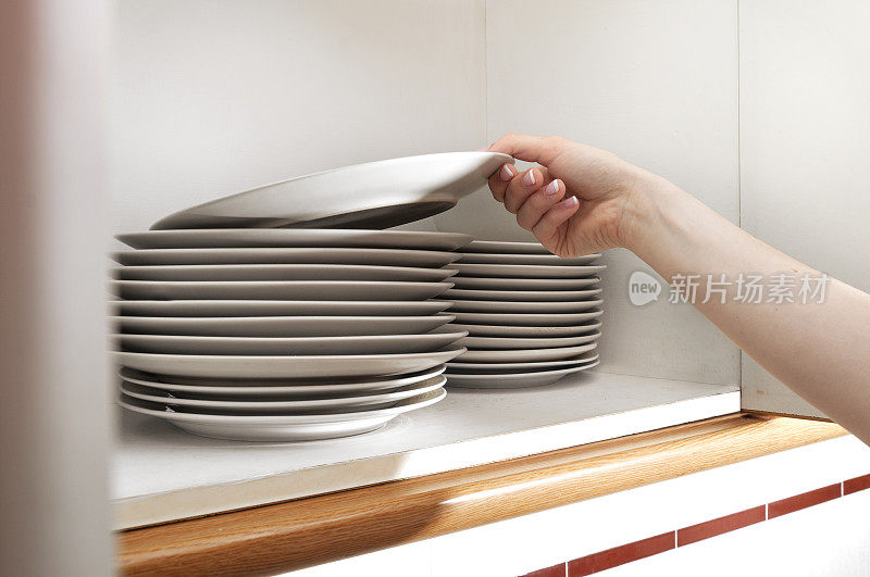 年轻的手拿着盘子在橱柜里，餐厅里，食物和食物