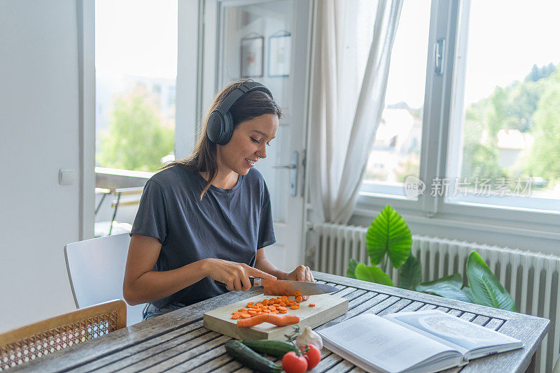 年轻女子一边做饭一边听录音