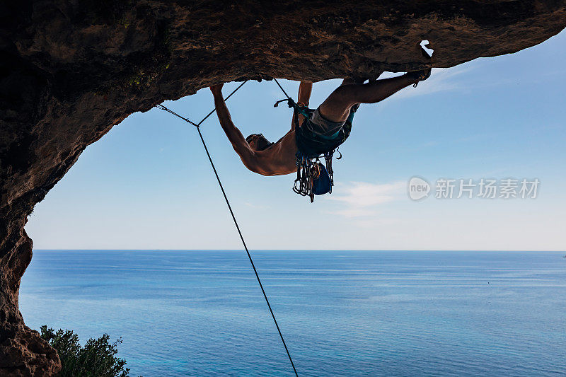 一位有经验的男性攀登者紧紧抓住岩壁