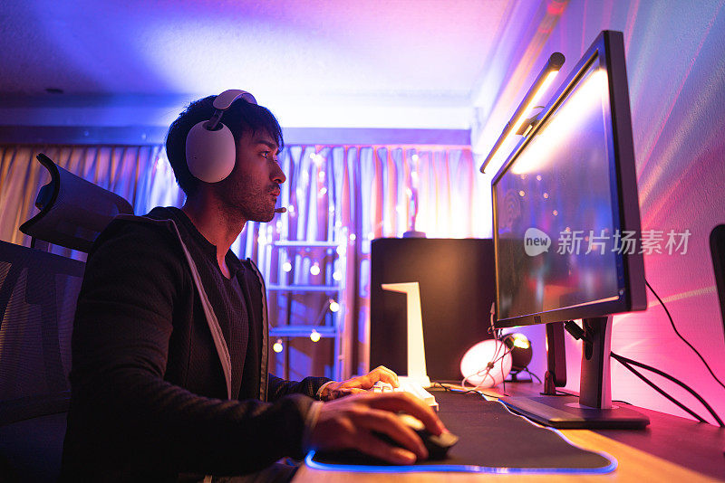 年轻的亚洲男性电子竞技玩家在房间里玩令人兴奋的在线游戏
