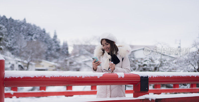 美丽的女子游客享受他们的日本之旅在雪的冬天。