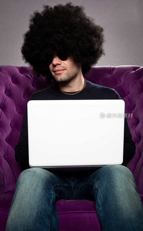 戴着非洲式假发和白色笔记本电脑的男人