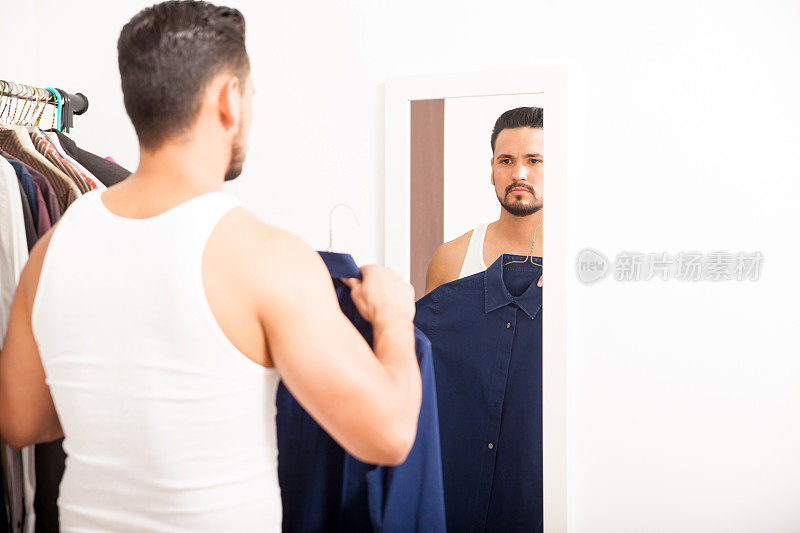 一个男人在镜子前穿衣服