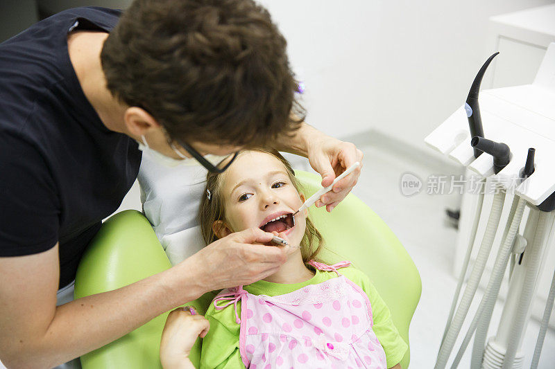 女孩坐在牙科椅上进行定期牙科检查