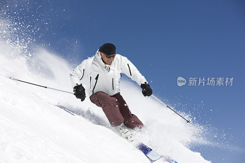 男滑雪者从斜坡上滑下来