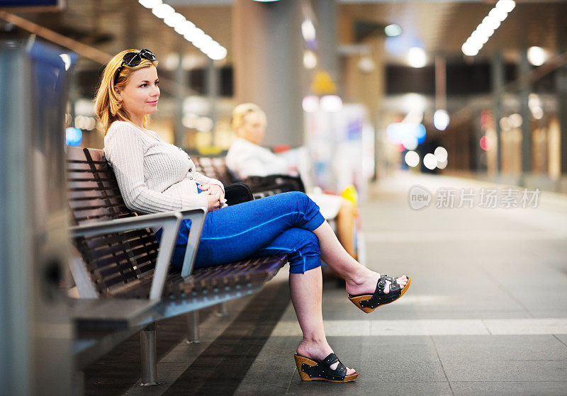 一个女人在地铁里等车。