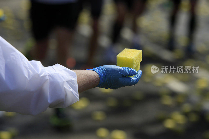 在马拉松比赛中发放黄色湿海绵的官员