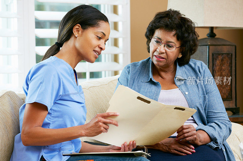 护士在家时与女老年患者讨论病历