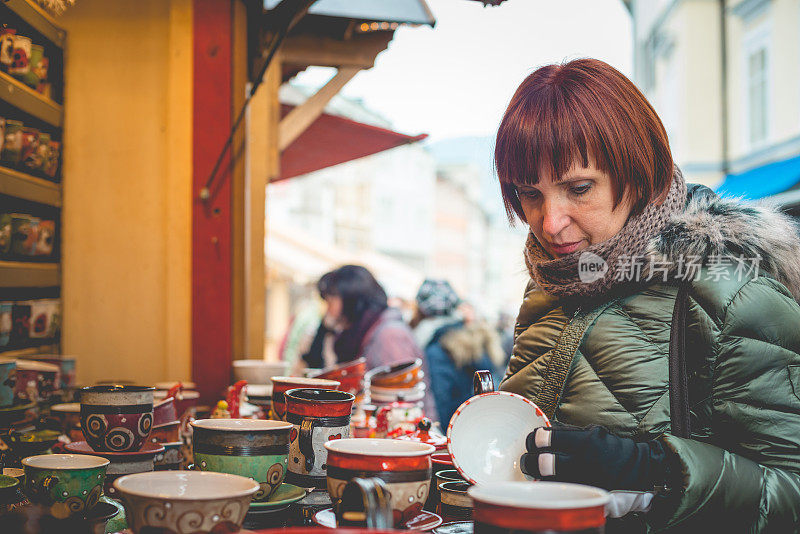 美丽的白人妇女在圣诞市场购物，奥地利，卡林西亚