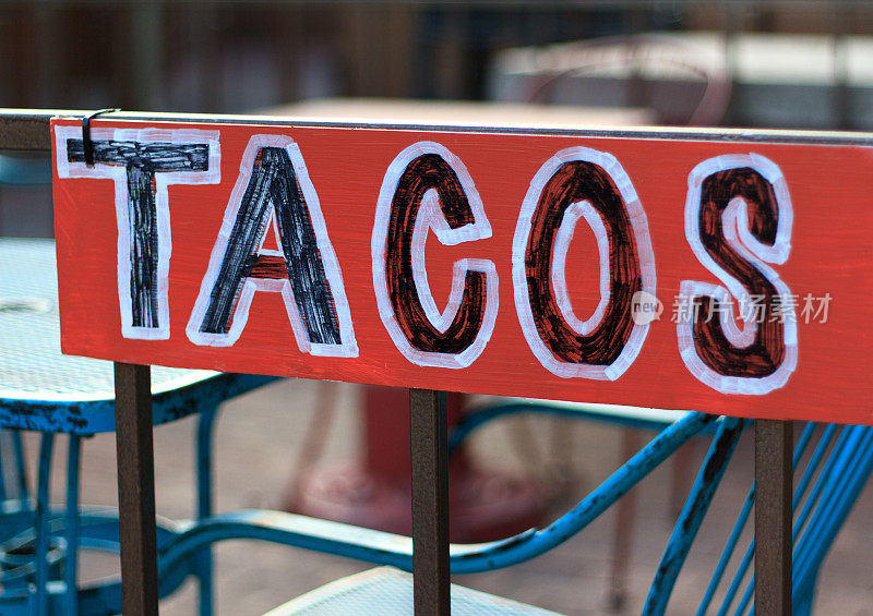 红色的“TACOS”标志和蓝色的户外桌椅