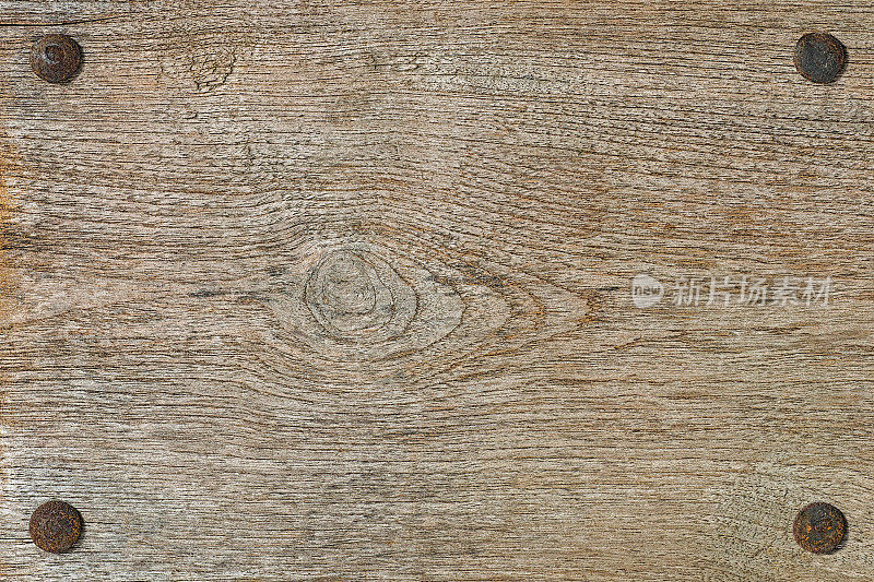 老风化的木板背景与四个生锈的螺栓。