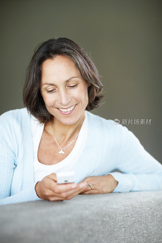 快乐成熟的女人在看手机短信