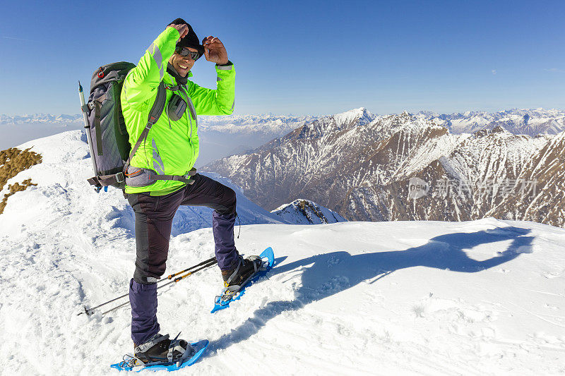 在山顶上穿着雪鞋的徒步旅行者