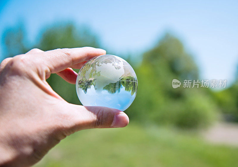 手握玻璃球在大自然中