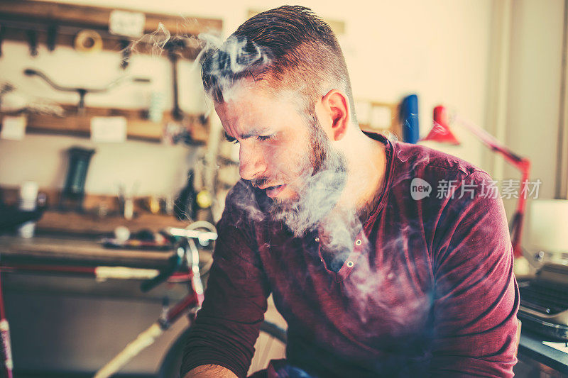 男人被香烟的烟雾笼罩着