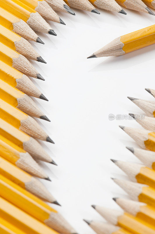一支黄色的铅笔，周围环绕着其他的铅笔和抄写空间