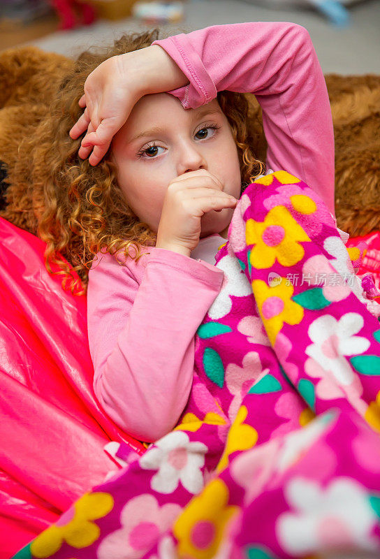 用粉色安全毯吮吸拇指的女孩