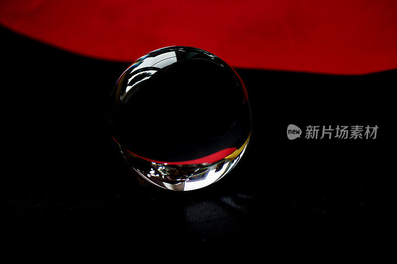 红黑丝绒纸背景上的玻璃球或水滴。清洁和光芒