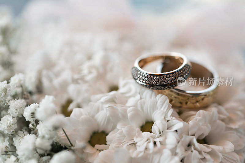 白色花朵上戴着结婚戒指。配件婚礼特写镜头。有选择性的重点