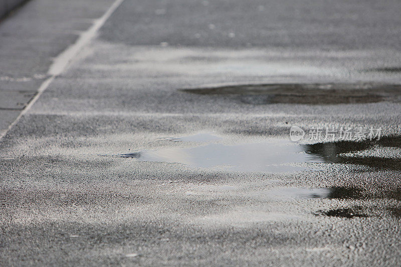 雨在城市的人行道上形成水坑