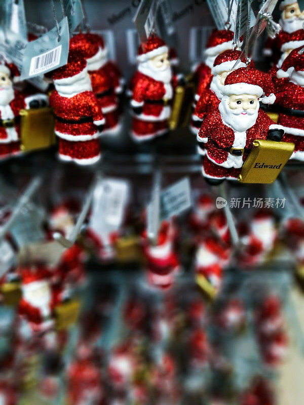 红色闪亮的圣诞老人圣诞树装饰品排成一排出售
