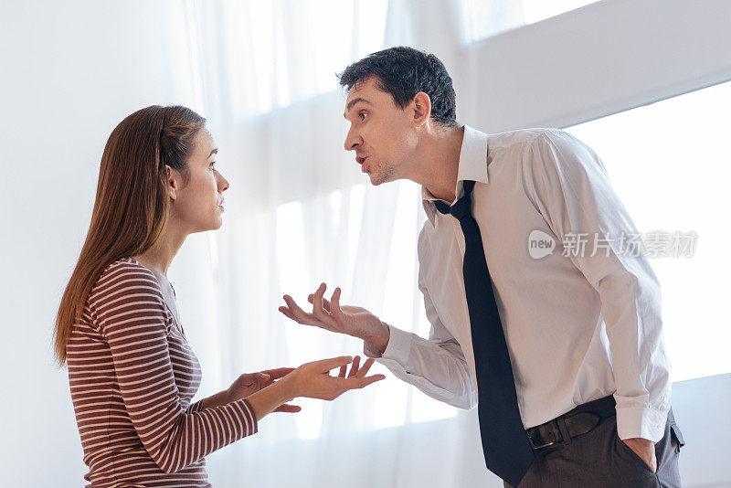 恼怒的愤怒的男人给他情绪化的妻子争论