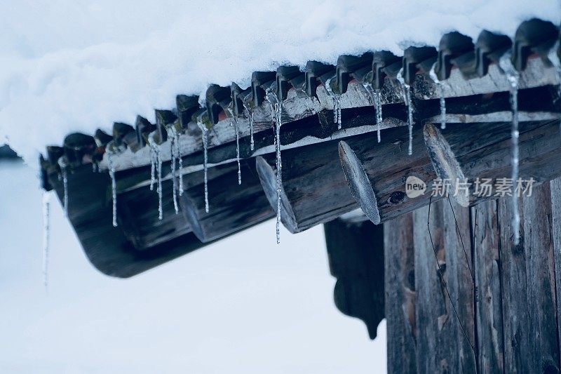 冰雪覆盖的冬季景观和屋顶上的冰柱