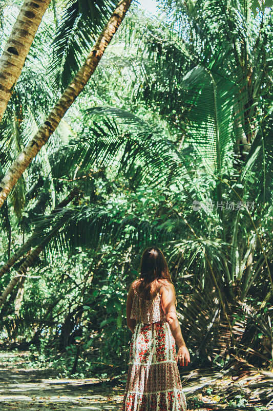 穿着长裙穿过丛林的女人