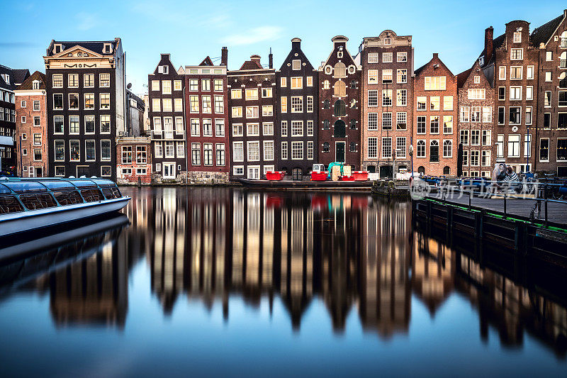 阿姆斯特丹的房屋在夜晚映照在运河水面上