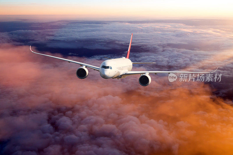 日落天空中的白色客机。