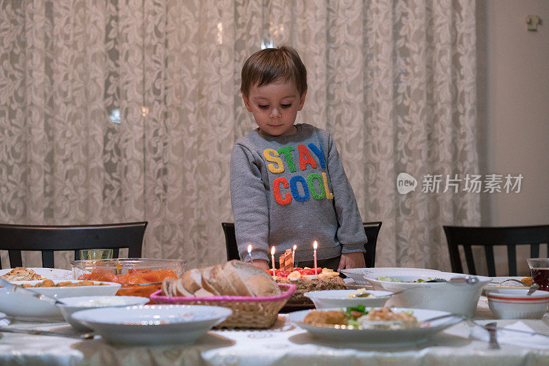 孩子吹灭生日蛋糕上的蜡烛