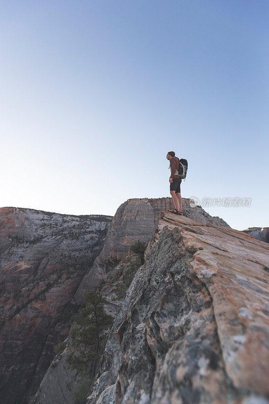 一位男性徒步旅行者站在悬崖边上