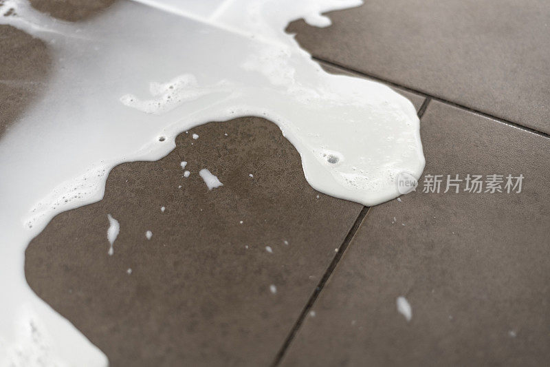 牛奶洒在瓷砖地板上