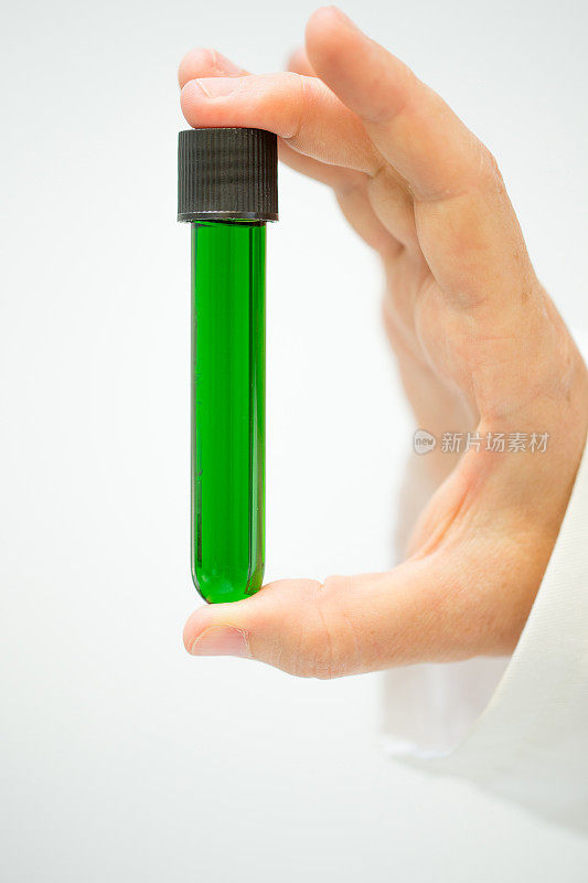 研究人员拿着一个含有叶绿素提取物的试管