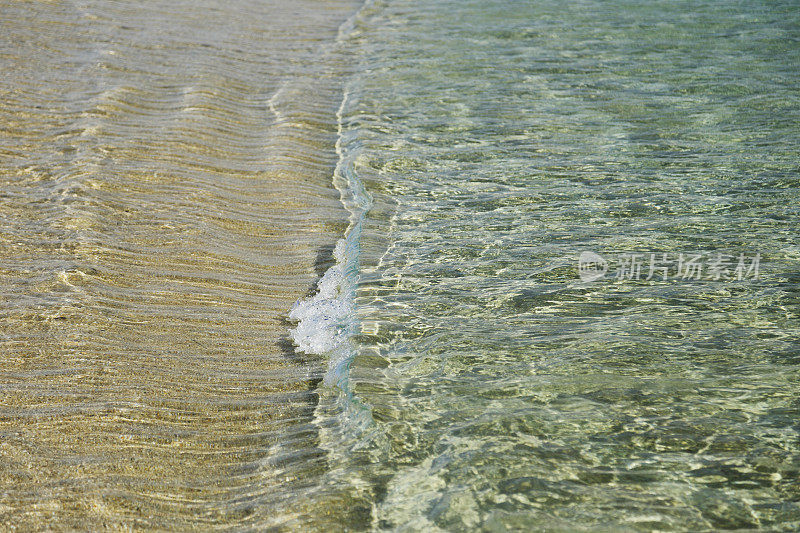 金色沙滩上水晶般的海水细节