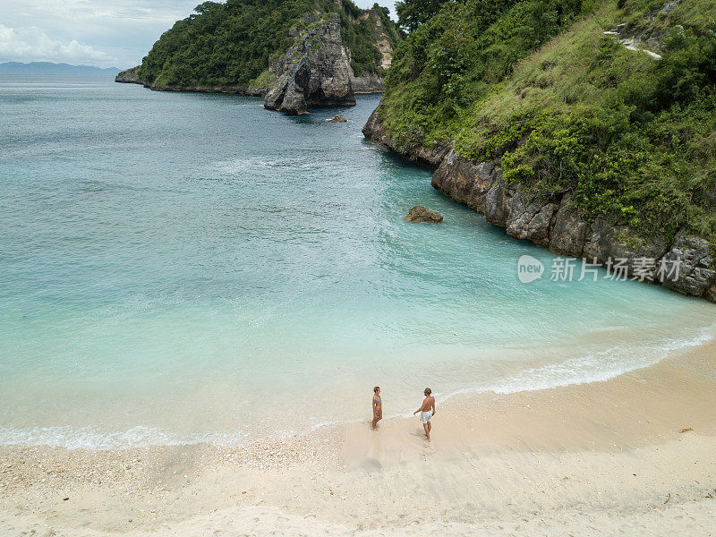 鸟瞰热带海滩上的年轻情侣享受度假和大自然，人们旅游探险的理念