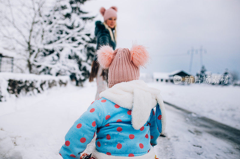 快乐的妈妈喜欢和她的孩子在雪地里玩