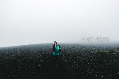 女人背包徒步旅行，虽然火山景观和风在冰岛无处